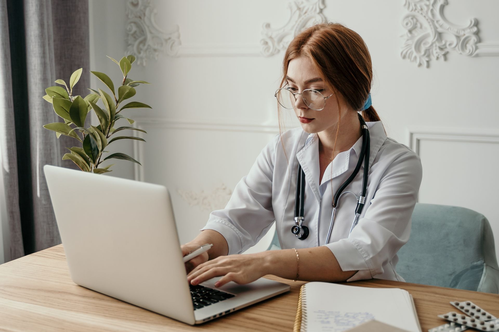 A medical professional working aged accounts receivable on a laptop